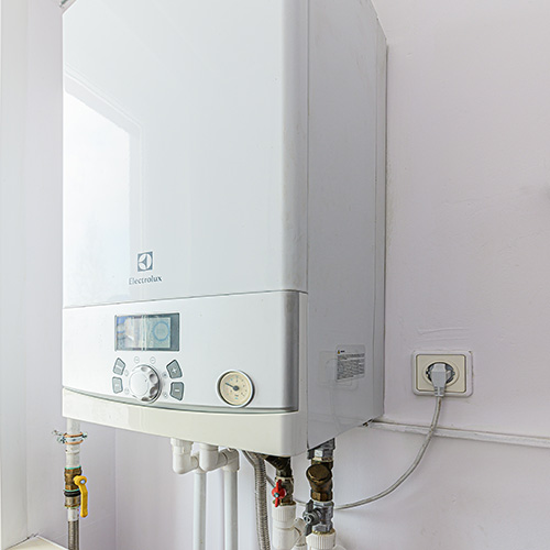 A residential hot water boiler mounted to the wall.